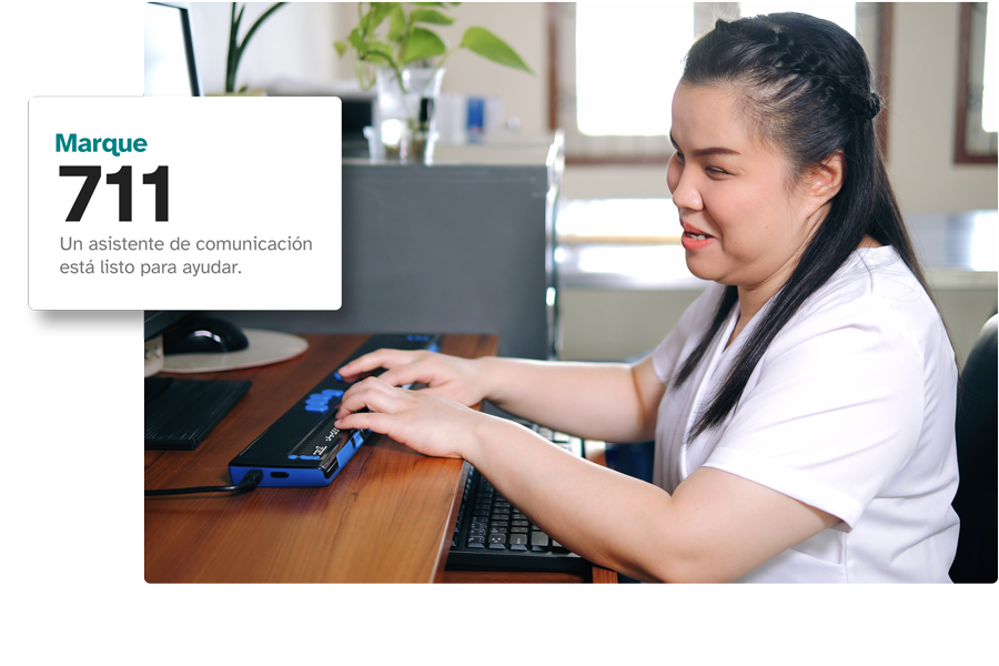 Una persona sordociega usando un dispositivo TeleBraille en un escritorio, con un recuadro que muestra 'Marque el 711. Una persona sordociega usando un dispositivo TeleBraille en un escritorio, con un recuadro que muestra 'Marque el 711.