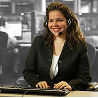 An adult female wearing a headset ready to help customers.